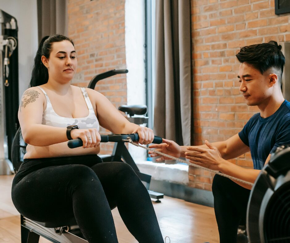 A personal trainer guiding a client through one-on-one strength training exercises, focusing on proper form and technique.